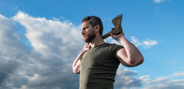confident man with axe. brutal caucasian man hold ax. brutal man on sky background. - Foto, imagen