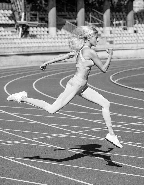 Full of energy. female athlete ready for sprint sport workout. trainer or coach training. marathon. energetic and sporty. sexy fitness woman in sportswear. athletic lady run on stadium running track. - 写真・画像