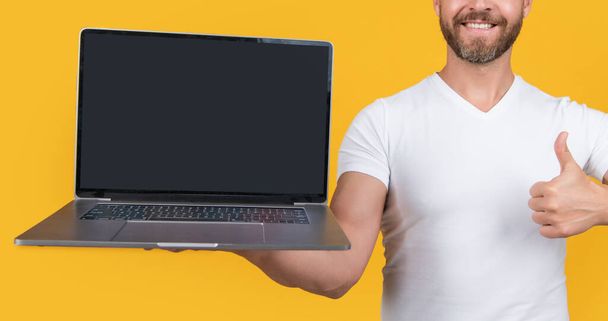 showing screen in selective focus. man showing screen of laptop. man showing screen with copy space. man showing screen isolated on yellow background. - Φωτογραφία, εικόνα