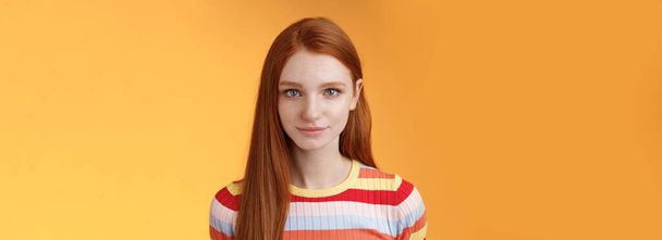 Attractive young sincere redhead girl clean pure perfect skintone smiling modest look camera friendly delighted standing relaxed awaiting gazing silly tenderly, posing orange background. Copy space - Photo, Image
