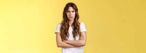 Upset jealous moody clingy girlfriend sulking offended cross hands chest blocking pose frowning disappointed complaining unfair treatment stand yellow background bothered pouting childish. - Photo, Image