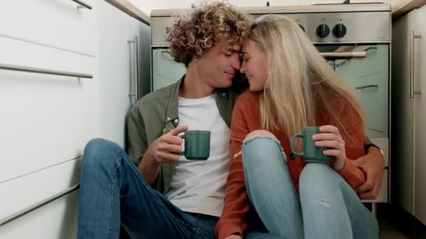 Couple, kiss and love, support and hug with coffee in kitchen for morning routine, nose and forehead touch, trust with commitment in strong relationship. Man, woman and care with romance and together. - Footage, Video