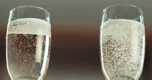 Nalévání šampaňské flétna, bubliny a nápoje na párty, oslavu a Nový rok v detailu. Sklenice na víno, zvětšení a šumivé bublinkové nápoje na oslavu alkoholovou pěnou stříkající rozmazané pozadí. - Záběry, video
