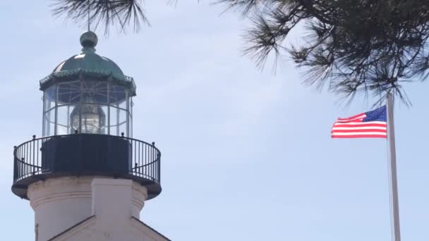 Vintage lighthouse tower, retro light house, old historic classic beacon with fresnel lens, american flag. Nautical navigation, 1855. Point Loma, San Diego, California USA. Seamless looped cinemagraph - Кадри, відео