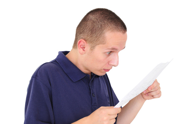 νεαρός άνδρας, κοιτάζοντας το χαρτί με δυσπιστία - Φωτογραφία, εικόνα