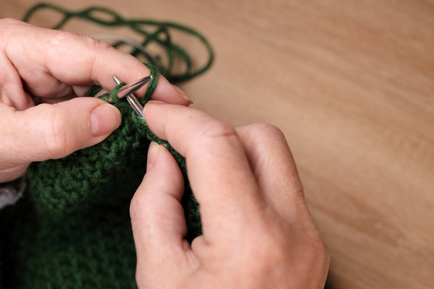 Woman knits with knitting needles from yarn. Concept of cozy knitting at home - Φωτογραφία, εικόνα