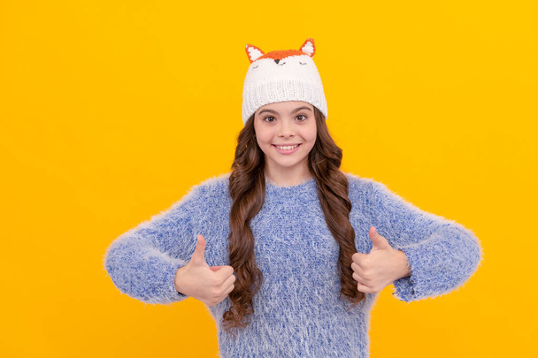 щаслива дитина в светрі і капелюсі на жовтому тлі, зима
. - Фото, зображення