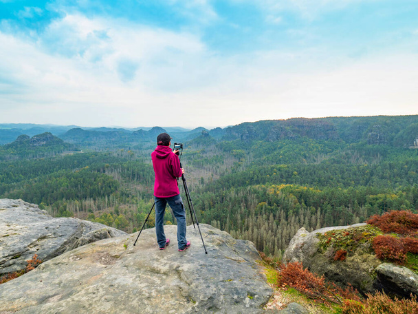 Touriste féminine avec caméra sur trépied prenant photo de voyage pic de montagne. Paysage naturel  - Photo, image