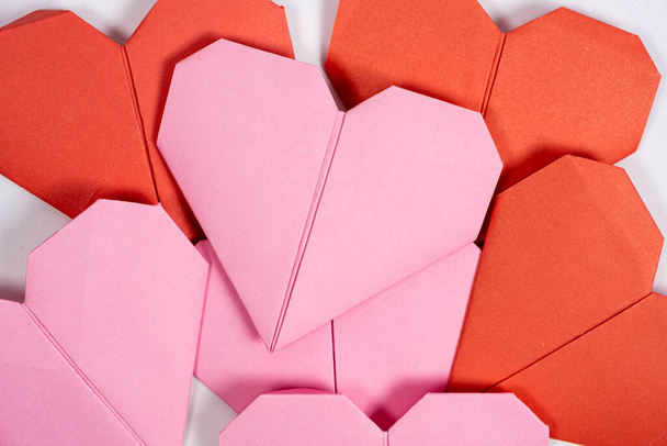 Origami zum Valentinstag - Herzen aus Papier auf weißem Hintergrund zum Selbermachen. - Foto, Bild