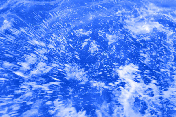 Defocus elmosódott átlátszó kék színű tiszta, nyugodt vízfelület textúra fröccsenések és buborékok. Trendi elvont természet háttér. Vízhullámok a napfényben fénymásolási hellyel. Kék akvarell ragyog - Fotó, kép