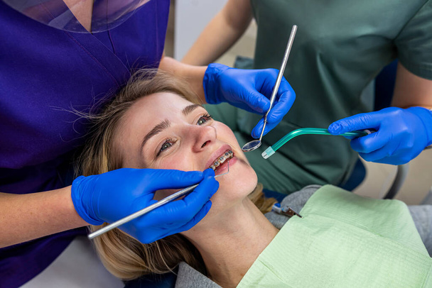 egy speciális fogászati klinikán, egy női fogorvos problémás fogakkal fogadja az ügyfeleket. Fogászati kezelés koncepciója - Fotó, kép