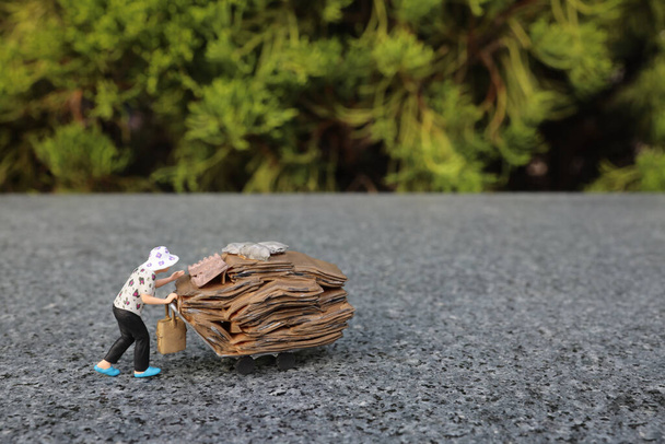 una mini figura spinge un carrello carico di borse attraverso - Foto, immagini