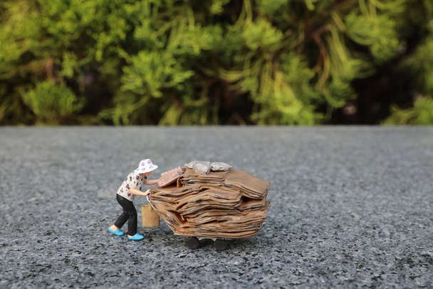 une mini figurine pousse un chariot chargé de sacs à travers - Photo, image