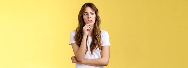 Need think what do how solve situation. Perplexed focused serious-looking thoughtful woman pouting touch lip look away pondering deep thinking standing yellow background hesitant. Copy space - Photo, Image