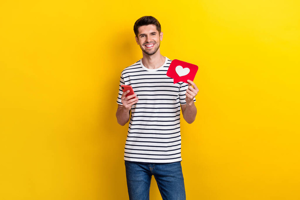 Portrait of positive person hold use telephone paper like card instagram twitter facebook isolated on yellow color background. - Foto, immagini