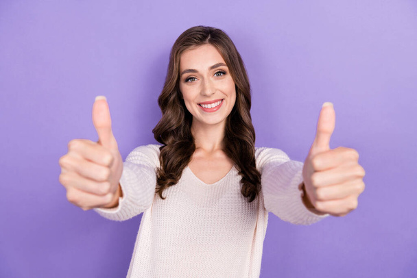 Photo of smiling good mood brunette wavy hairdo girl wear white jumper showing thumbs up likes look you camera isolated on purple color background. - Foto, imagen