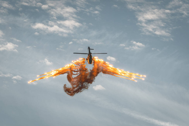 Leszno, Poland - June, 17, 2022: Antidotum Airshow Leszno, Eurocopter AS332 Super Puma. The helicopter pilot demonstrates the defense system, releases a large number of flares in the air. - Photo, Image