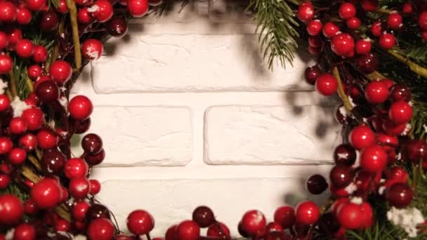 Bela imagem de fundo de vídeo de uma grinalda de Natal com bagas vermelhas em um fundo branco. A grinalda de Ano Novo. Decoração de Ano Novo da casa - Filmagem, Vídeo