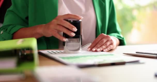 Bizneswoman umieszcza pieczęć na dokumentach finansowych w biurze. Zatwierdzenie umowy handlowej - Materiał filmowy, wideo