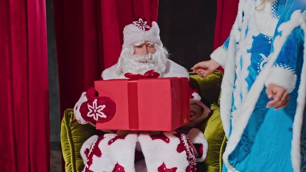 Санта і місіс Санта бажають веселого Різдва, дарують подарунки і прикрашають дерево
 - Фото, зображення