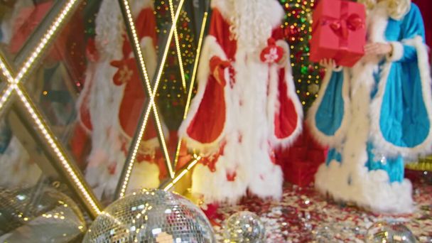 kerstman en mevrouw kerstman wensen vrolijk kerstfeest, geven geschenken en versieren de boom - Foto, afbeelding