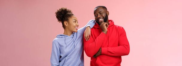 Two best friends having fun man smiling woman leaning his shoulder talking laughing joking like spending time together, standing pink background chit-chat confident relaxed poses. Copy space - 写真・画像
