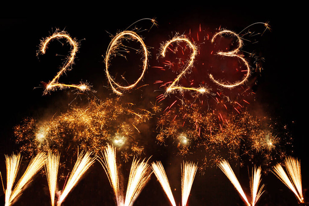 2023 Happy New Year written with Sparkler firework on black background - Photo, Image