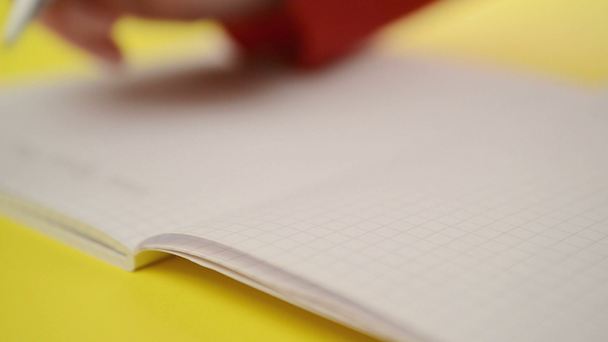 Γυναίκα σημειώσεις εγγράφως στο σημειωματάριο, κοντινό πλάνο σταθερή πλάνα με επιλεκτική εστίαση αφ - Πλάνα, βίντεο