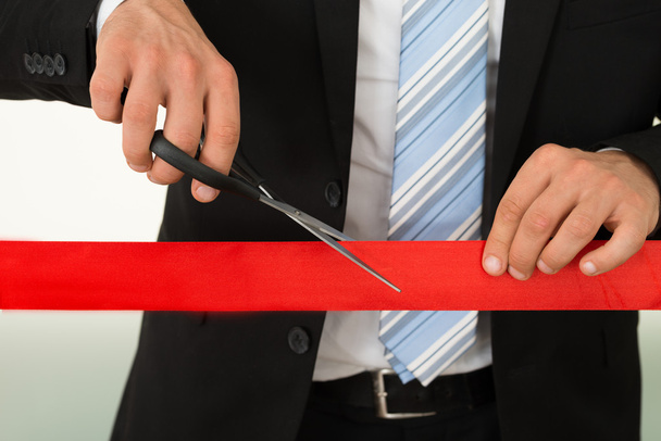 Businessman Cutting Red Ribbon With Scissors - Foto, Imagem