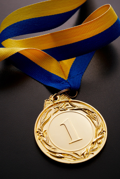 Medalha de ouro no escuro
 - Foto, Imagem