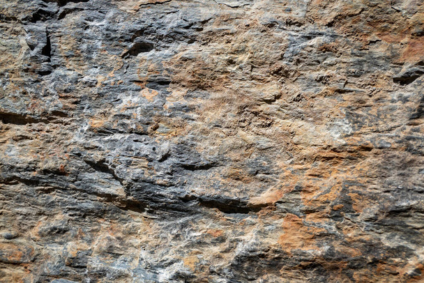Gestructureerd stenen oppervlak met enkele kleine scheurtjes - Foto, afbeelding