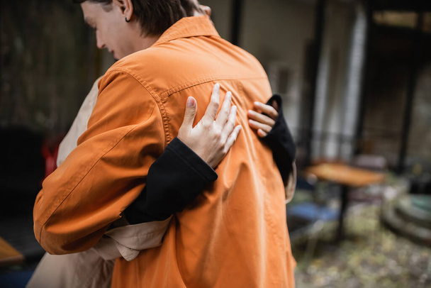 Mujer abrazando novio borroso en la terraza de la cafetería  - Foto, Imagen