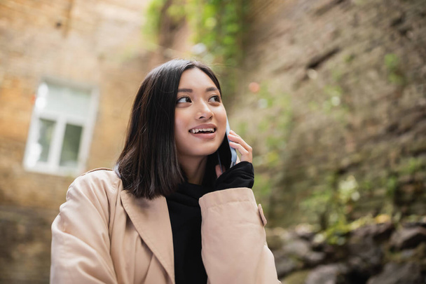 positive asiatique femme parler sur téléphone mobile en plein air café  - Photo, image
