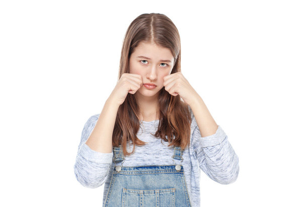 Sad young fashion girl in jeans overalls isolated  - Foto, Bild