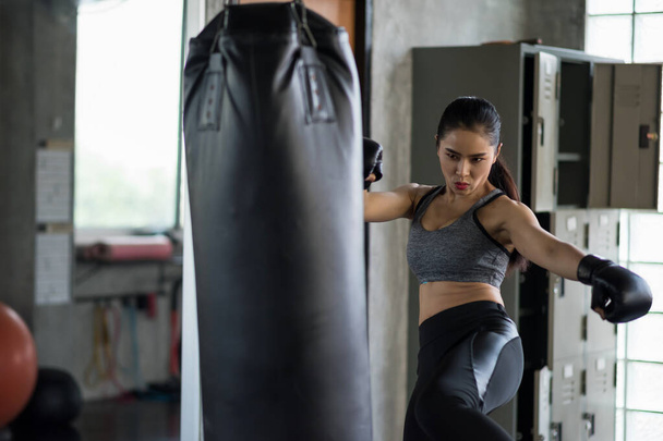 Silné asijské box žena kop velký punching bag ve fitness tělocvičně. Sportovní dívka trénink Muay Thai pro kulturistiku a zdravý životní styl konceptu. cvičení ve sportovním klubu. - Fotografie, Obrázek