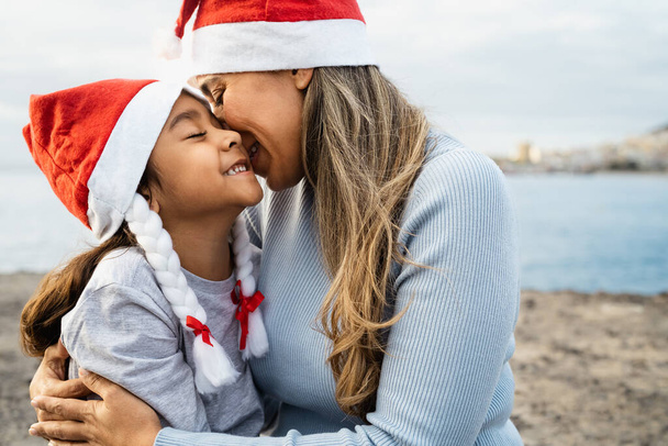 クリスマス休暇中に子供と優しい瞬間を持っている幸せなラテン語の母-家族と休日のコンセプト - 写真・画像