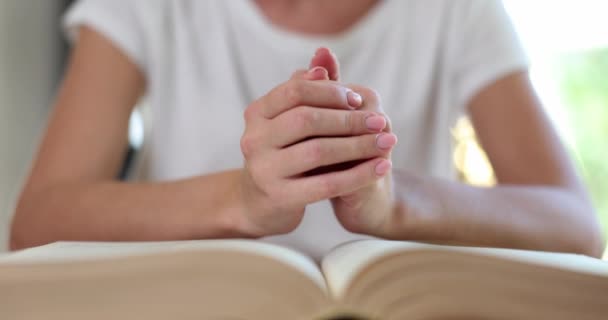 La mujer ora con las manos agarradas a la fe y a la esperanza bíblicas. Crisis de vida cristiana y oración a Dios - Imágenes, Vídeo
