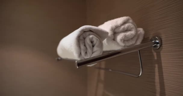 Dos toallas blancas limpias están cuidadosamente dobladas en la percha. Higiene corporal diaria - Metraje, vídeo