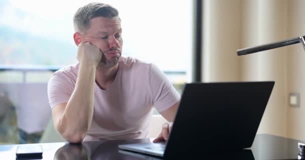 Üzülmüş üzgün adam dizüstü bilgisayara bakıp problem çözmeyi düşünüyor. Bilgisayarda çalışan depresif erkek serbest çalışan - Video, Çekim