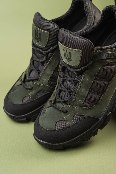 Military sneakers on a green background. Khaki army shoes - Valokuva, kuva