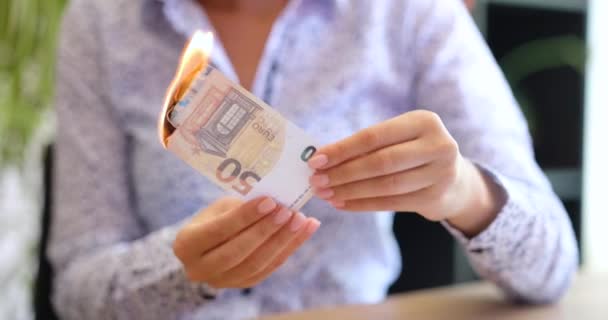Деловая женщина с деньгами в руках сжигает банкноты на 50 евро. Финансовая инфляция в Европе и трата денег - Кадры, видео