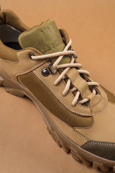 Military sneakers on a beige background. Khaki army shoes - Foto, Imagem
