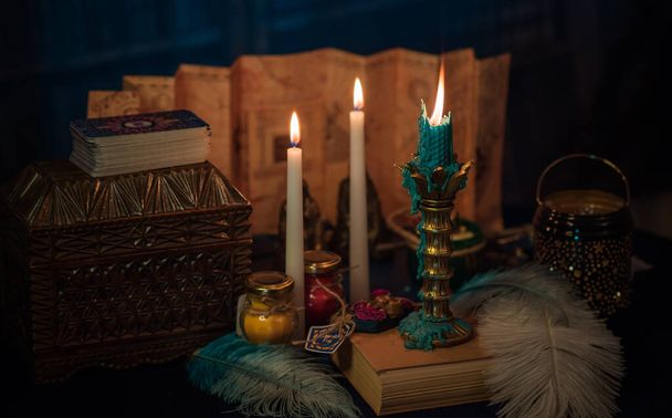 Tarjetas de adivinación y velas encendidas en una mesa sobre fondo místico - Foto, Imagen