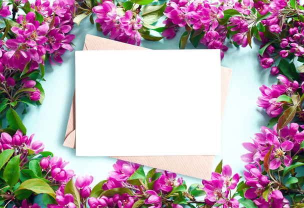 青い背景と封筒に花の枝や花弁。春のコンセプト. - 写真・画像