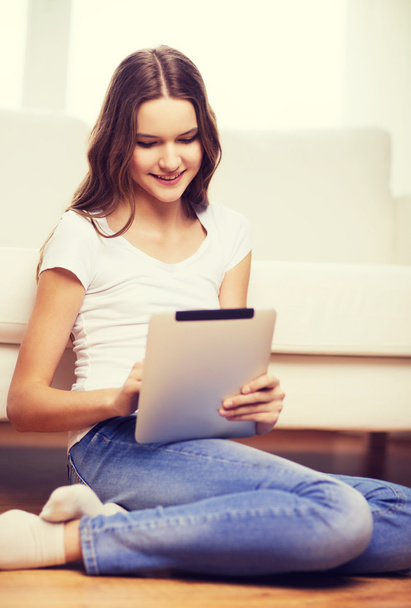 smiling teenage girl with tablet pc at home - Fotografie, Obrázek