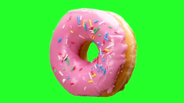 Een donut draaiend tegen een groene achtergrond  - Video