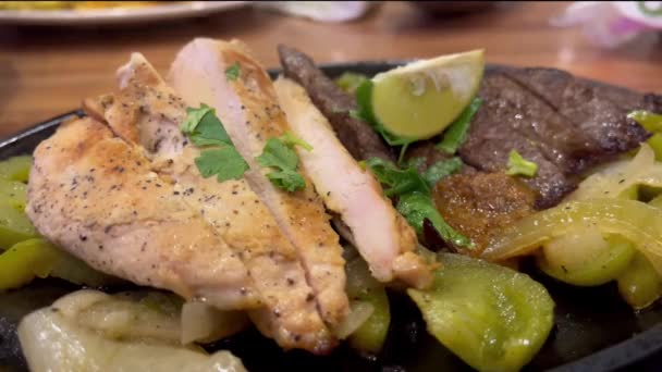 Lezárt felvétel grillezett csirkéről és marhahúsról öntöttvas tányéron - Felvétel, videó