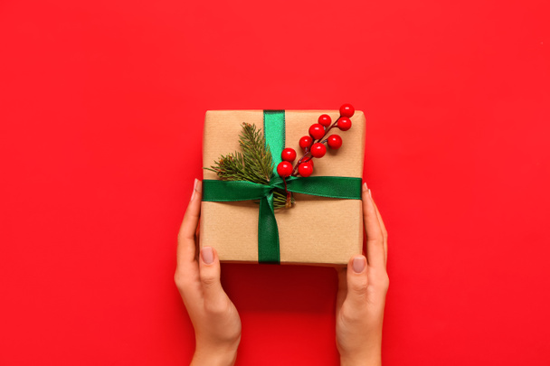 Žena s vánoční dárková krabice na červeném pozadí, horní pohled - Fotografie, Obrázek