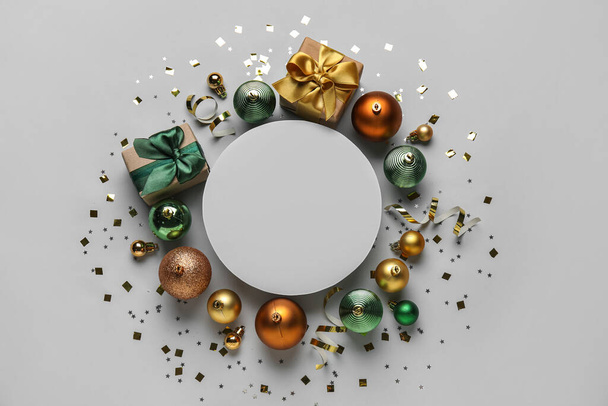 Состав с пустой карточкой, рождественские шары, подарок и конфетти на светлом фоне - Фото, изображение