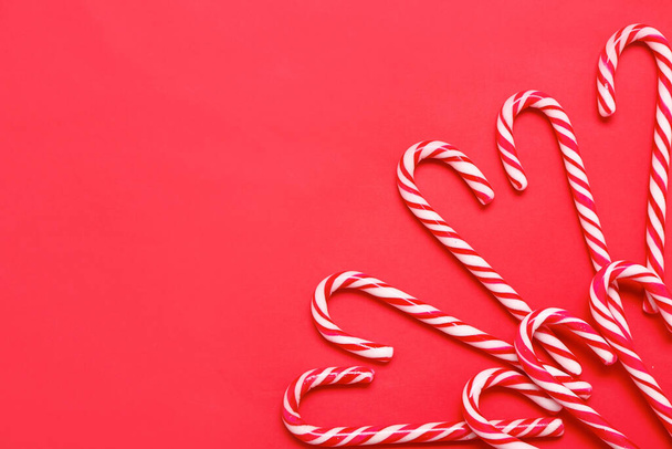 Composition with tasty candy canes on red background - Photo, Image